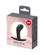 Różowo-szare opakowanie Fun Factory z produktem Bootie M, plug analny widoczny przez przezroczyste okienko