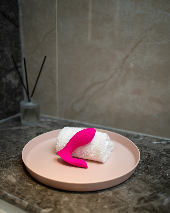 Wibrator Lovense Flexer umieszczony na marmurowym blacie w łazience, demonstrujący wodoodporność produktu.