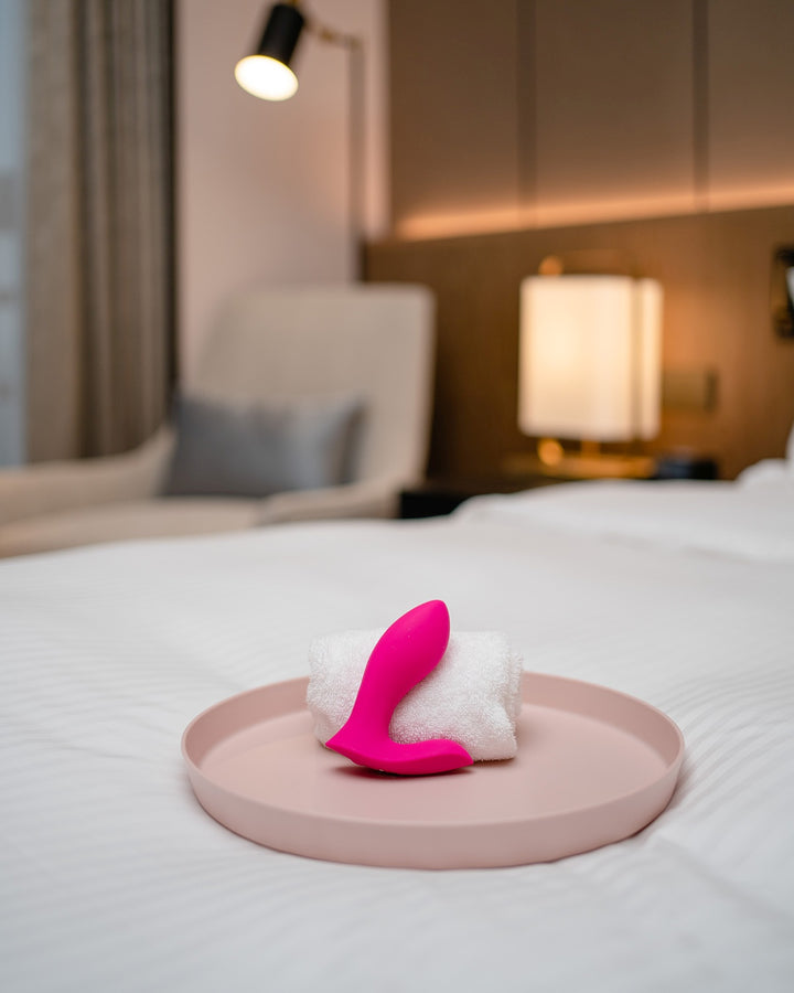 Wibrator Lovense Flexer na tle pościeli na łóżku, podkreślając intymny charakter produktu.