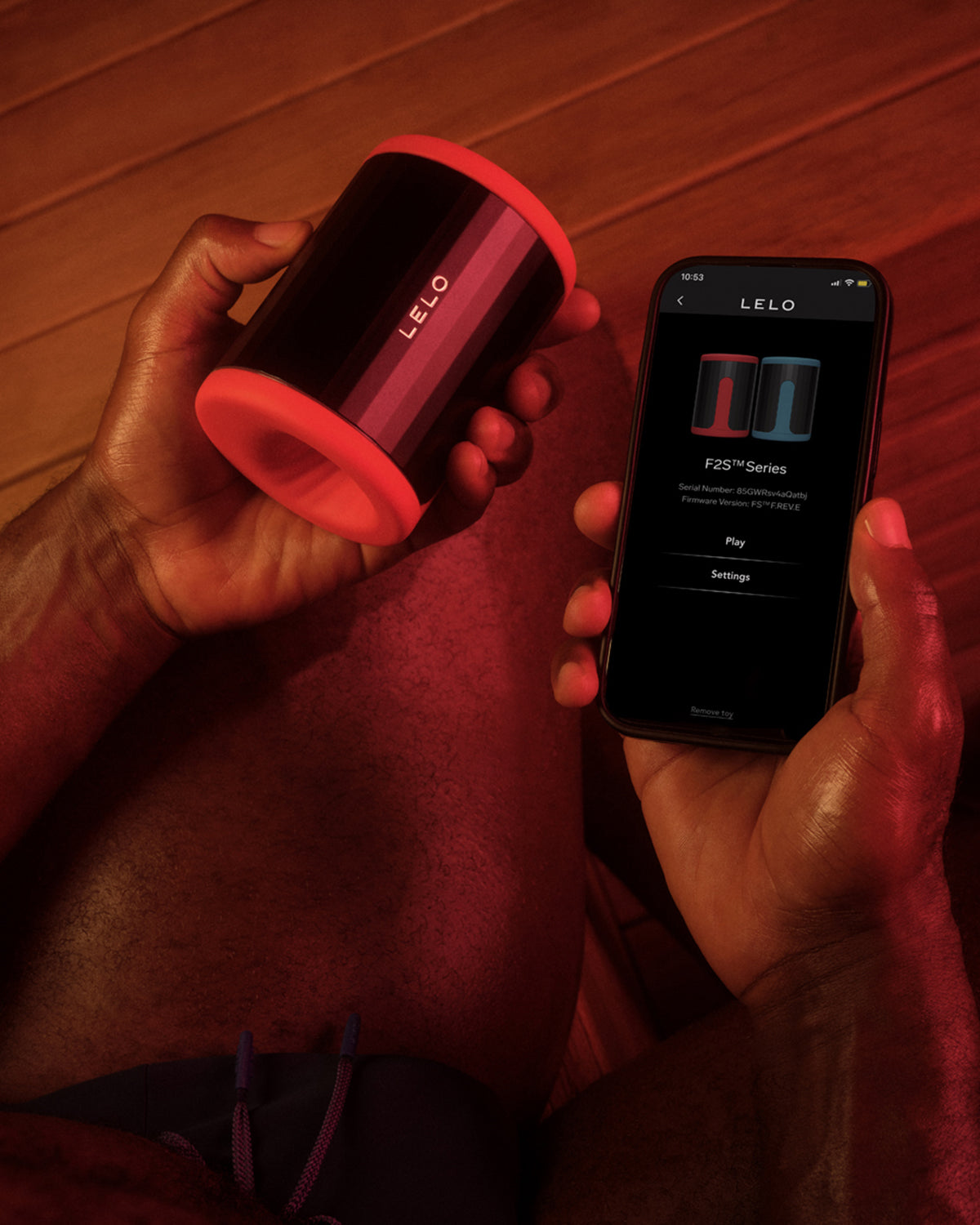 Masturbator LELO F2S - w dłoni ze smartfonem i aplikacją LELO do zdalnego sterowania