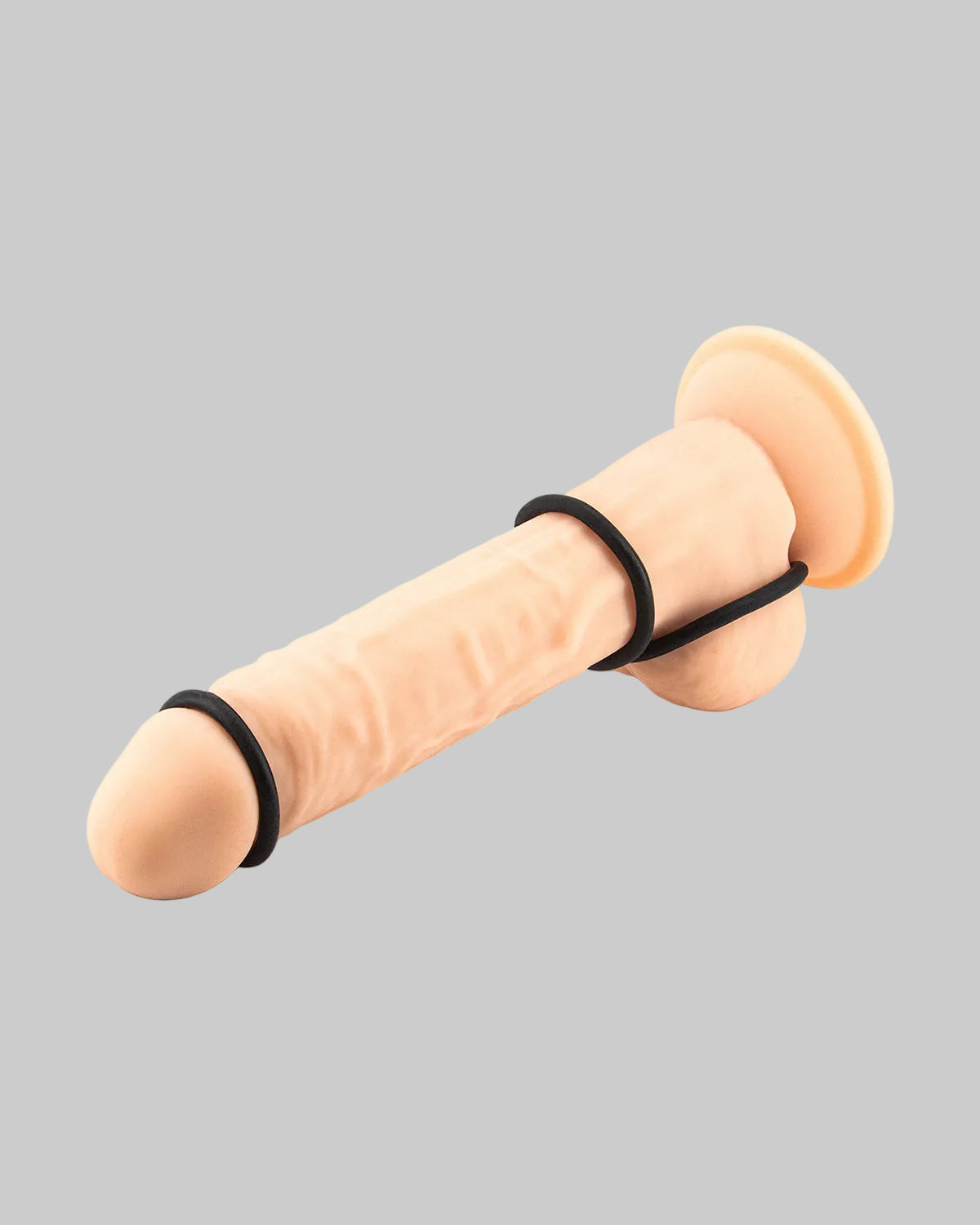 Beżowy realistyczny dildo z czarnymi pierścieniami na podstawie i wzdłuż trzonu